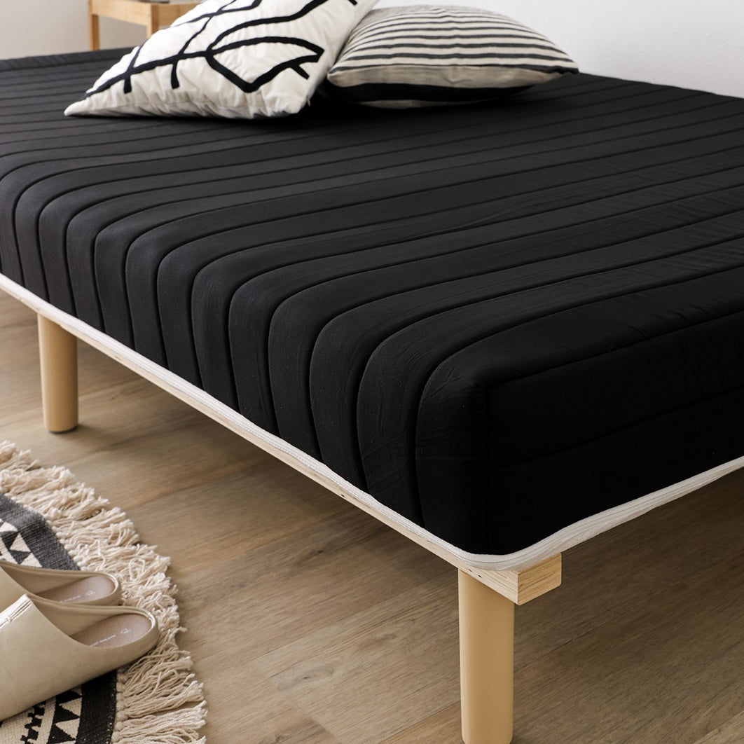 黒のマットレス一体型ベッドが部屋に置いてある