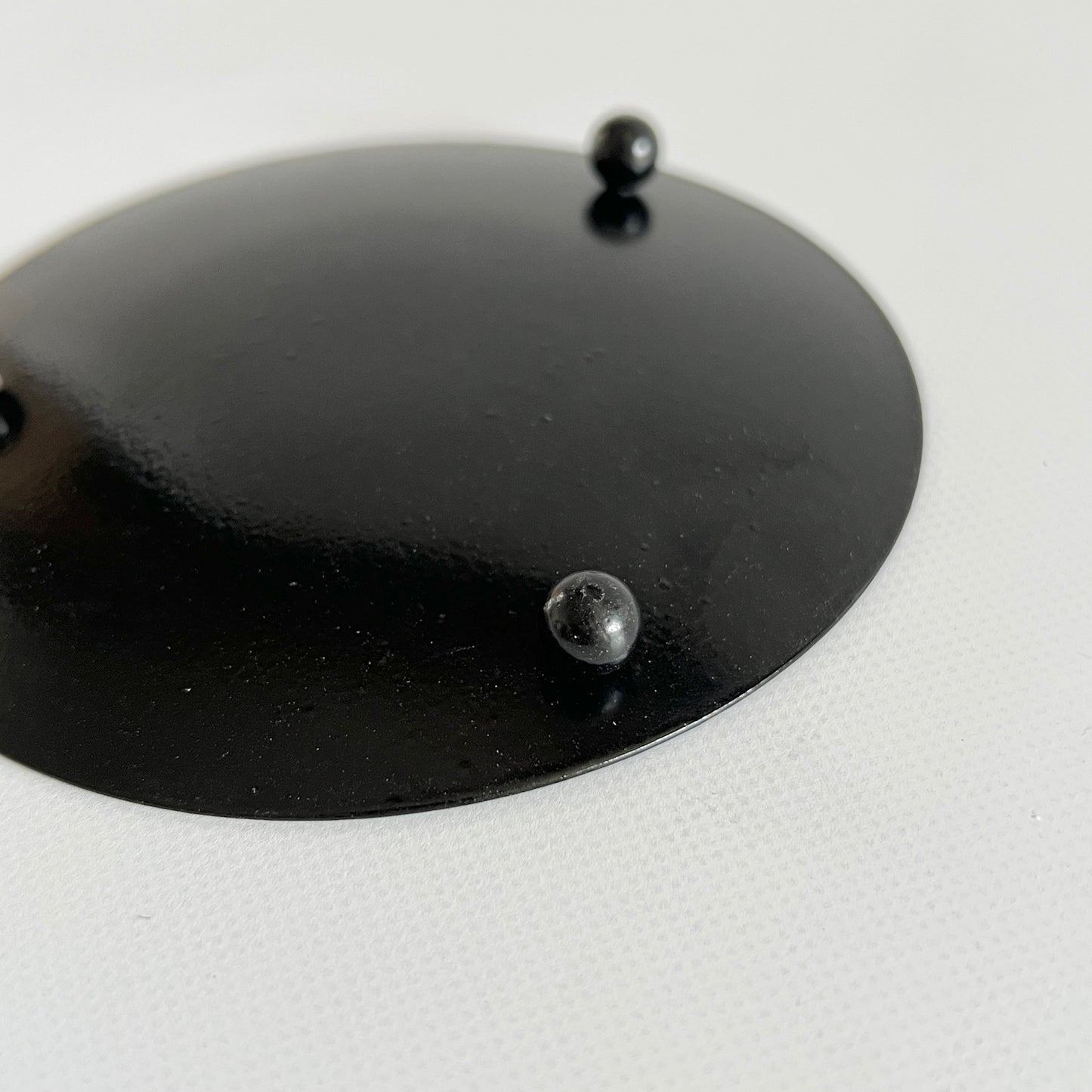 底面から撮影した脚付のブラックの鉄製の丸いプレート
