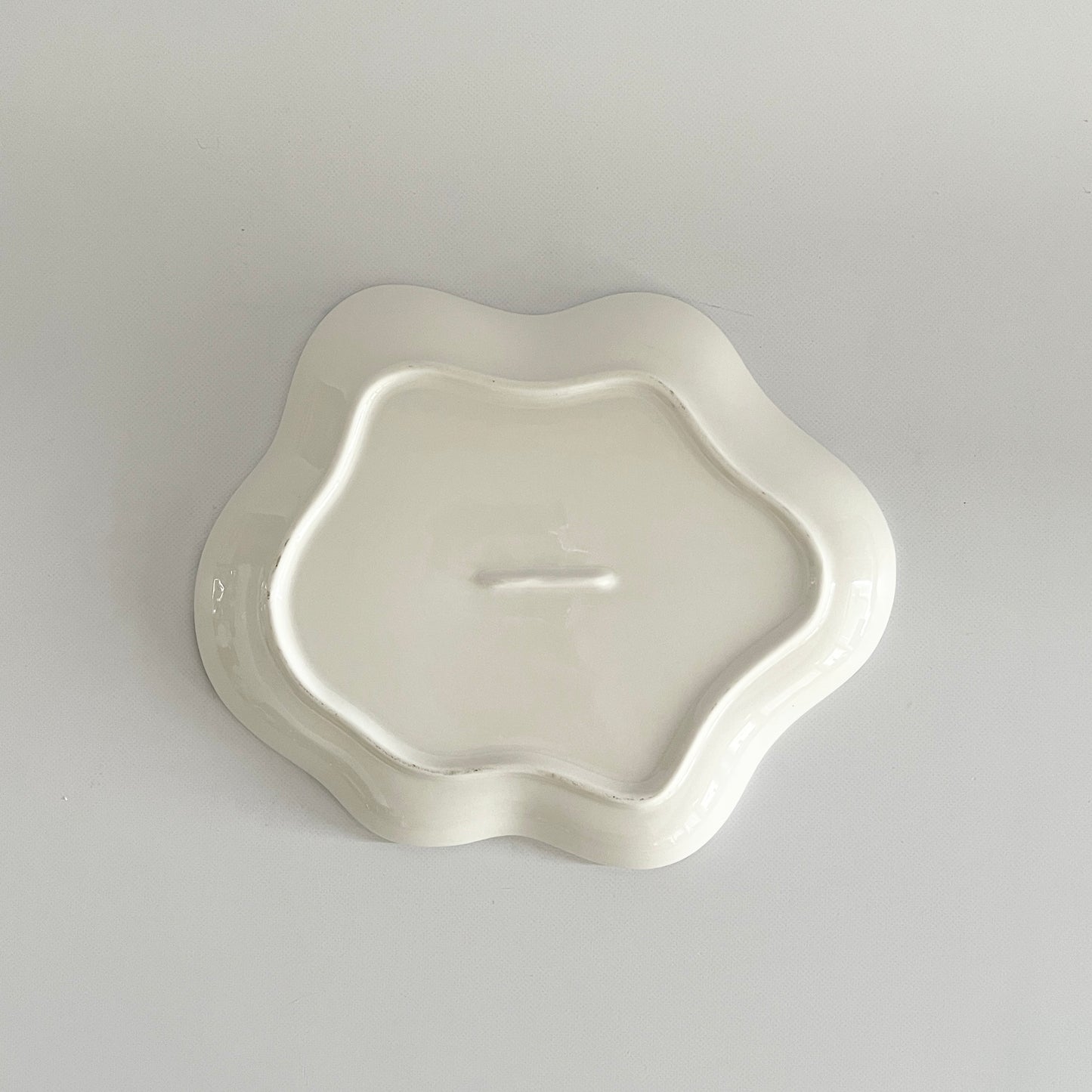 白黒と白グリーンの格子柄のウェーブ型のプレートの底面