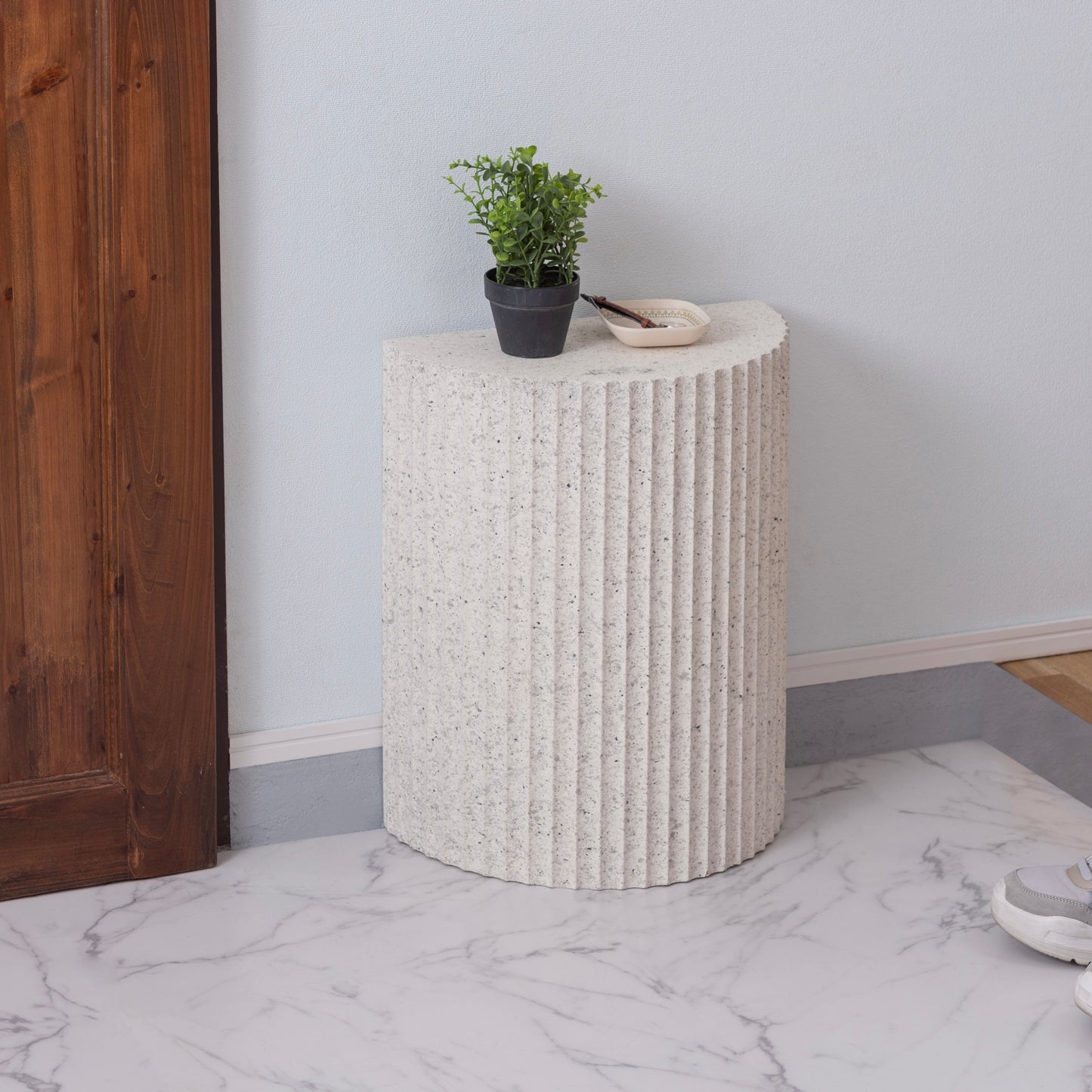 テラゾー柄の半円のスツールが玄関に置かれている様子