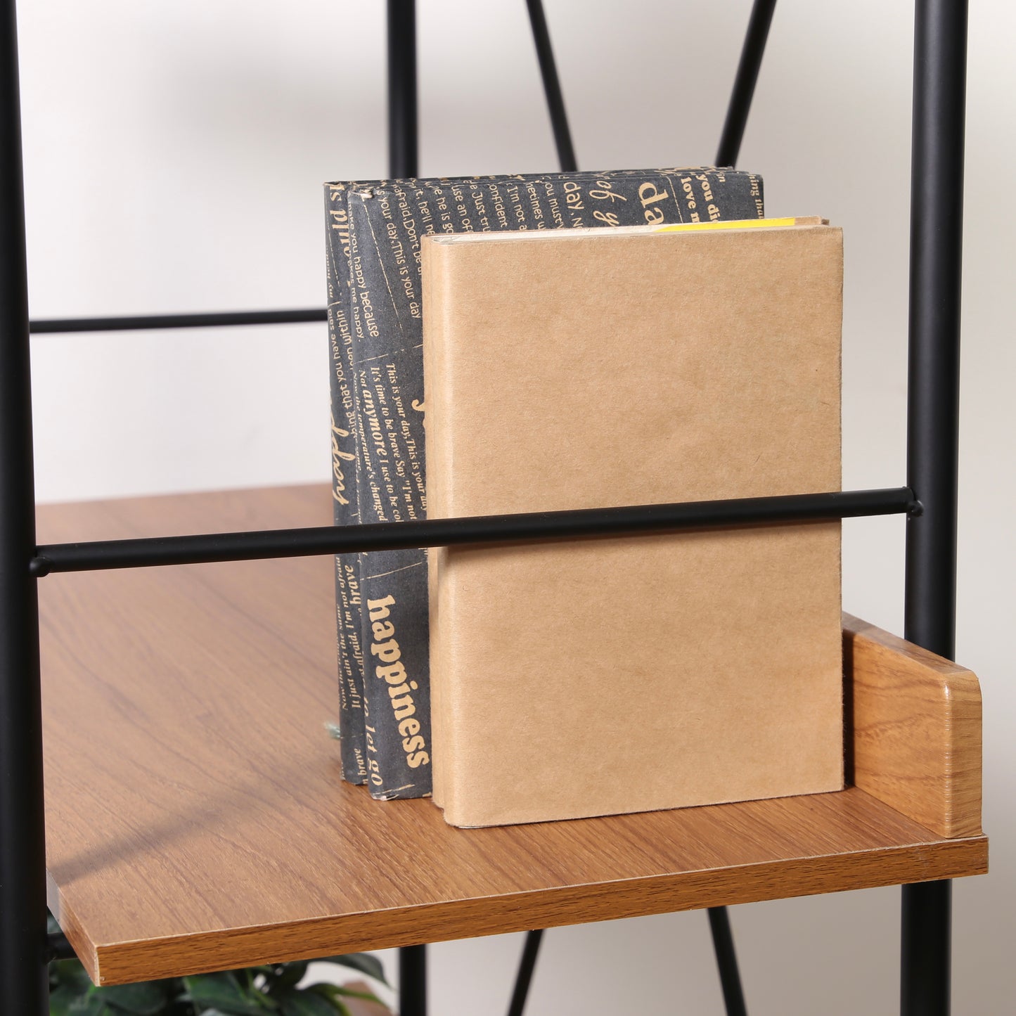 ウッド素材とブラックフレームの3段のオープンシェルフに本を収納している様子