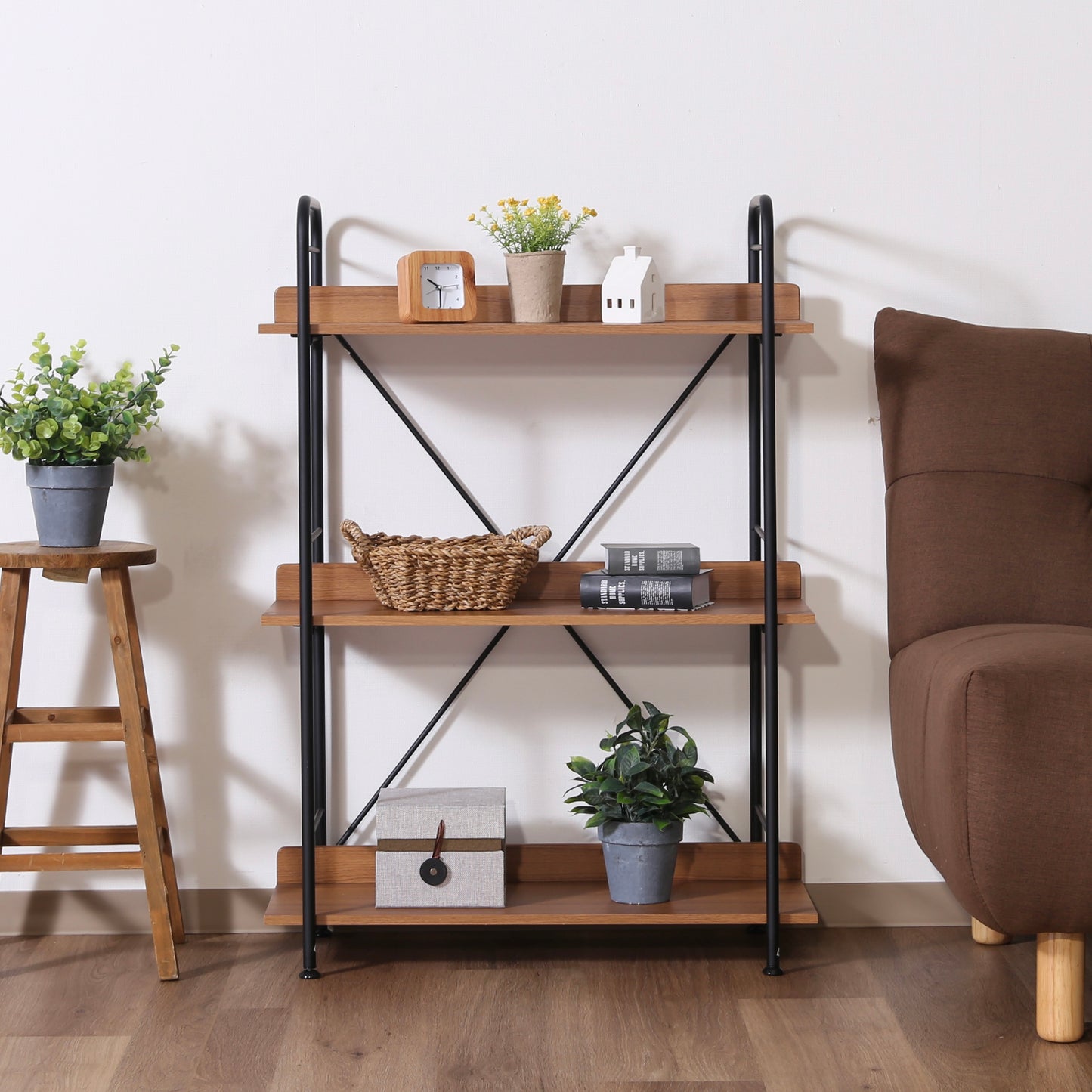 ウッド素材とブラックフレームの3段のオープンシェルフがソファ横に置かれている様子