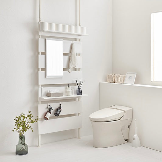 ホワイトの突っ張りミラー付きラックをトイレに設置している様子