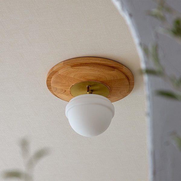 天然木とガラスシェードを組み合わせたシーリングライトが天井に設置されている様子