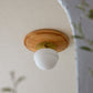 天然木とガラスシェードを組み合わせたシーリングライトが天井に設置されている様子
