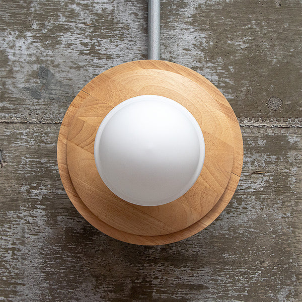 天然木とガラスシェードを組み合わせたシーリングライトが天井に設置されている様子