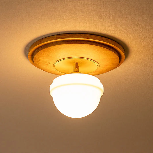 天然木とガラスシェードを組み合わせたシーリングライトが天井に設置されている様子