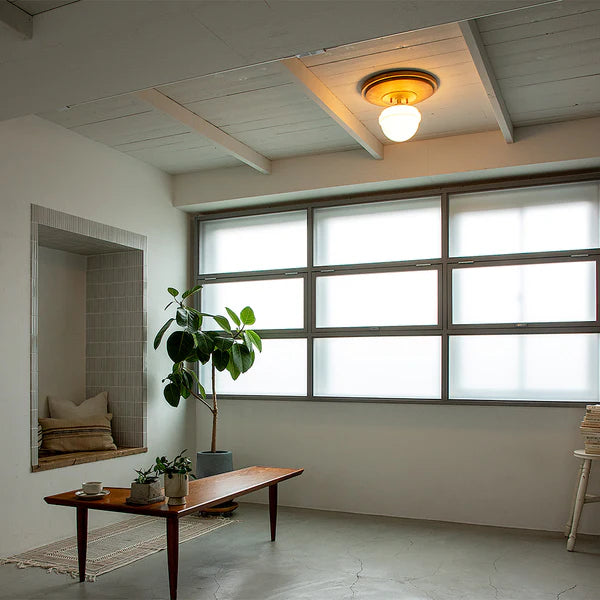 天然木とガラスシェードを組み合わせたシーリングライトが天井に設置されている様子