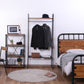 黒の金属と木製のウッドラック付きハンガーラックに服2着、帽子、箱が置かれています。