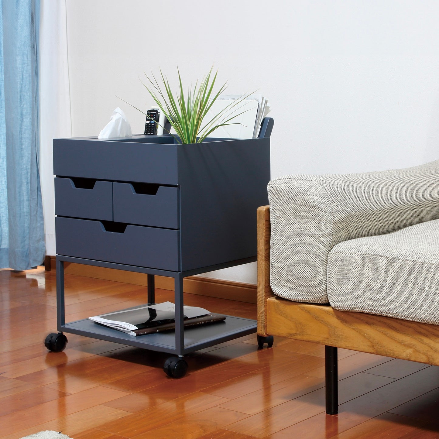 引き出しがたくさんついたネイビーのワゴンにティッシュや小物が収納されている様子
