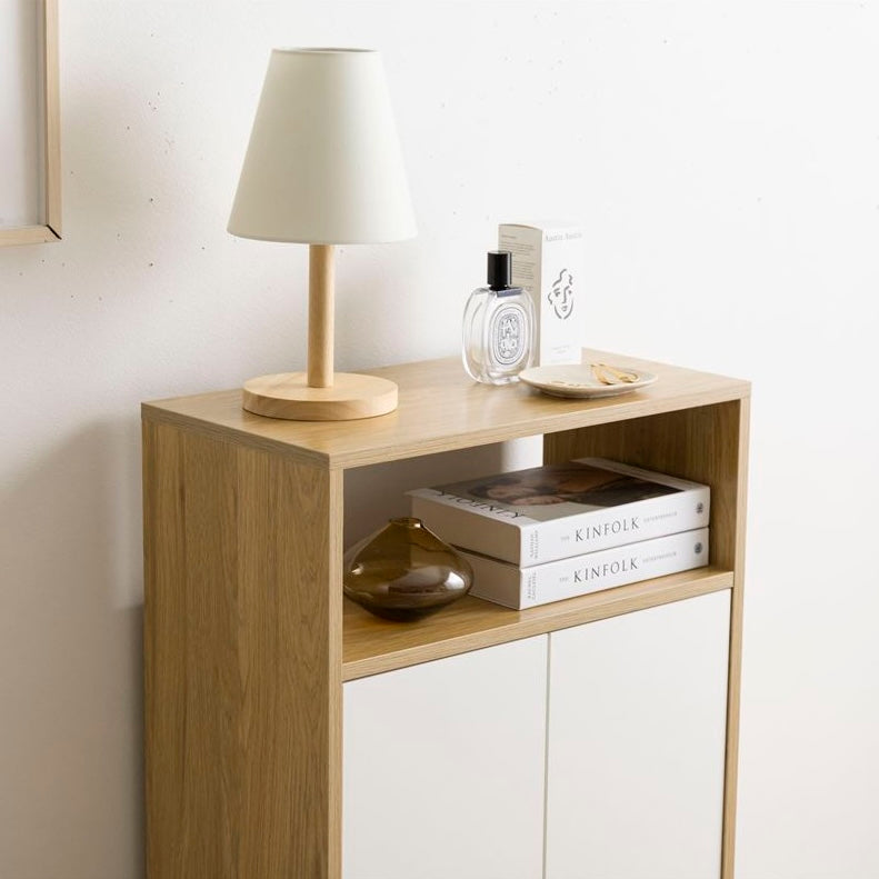 白とナチュラルウッドのバイカラーの扉付きの収納とオープン棚が組み合わさったキャビネットを部屋に置いている