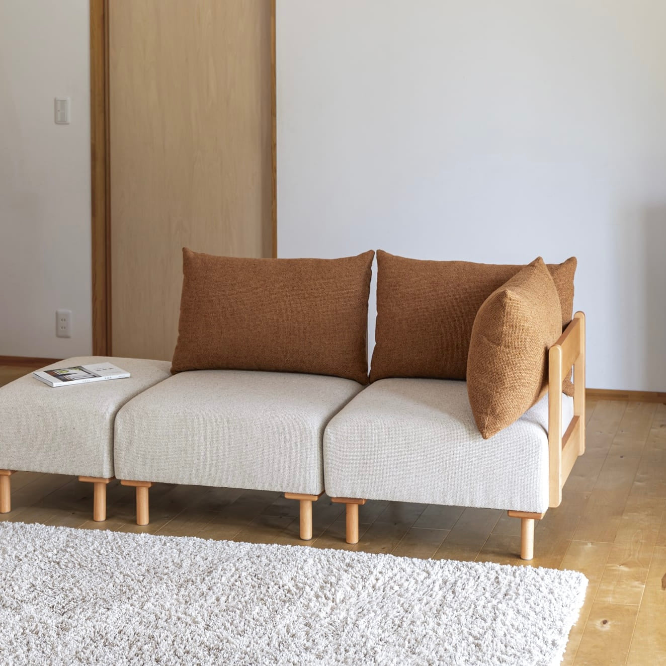 木製フレームのテラコッタオレンジのソファ