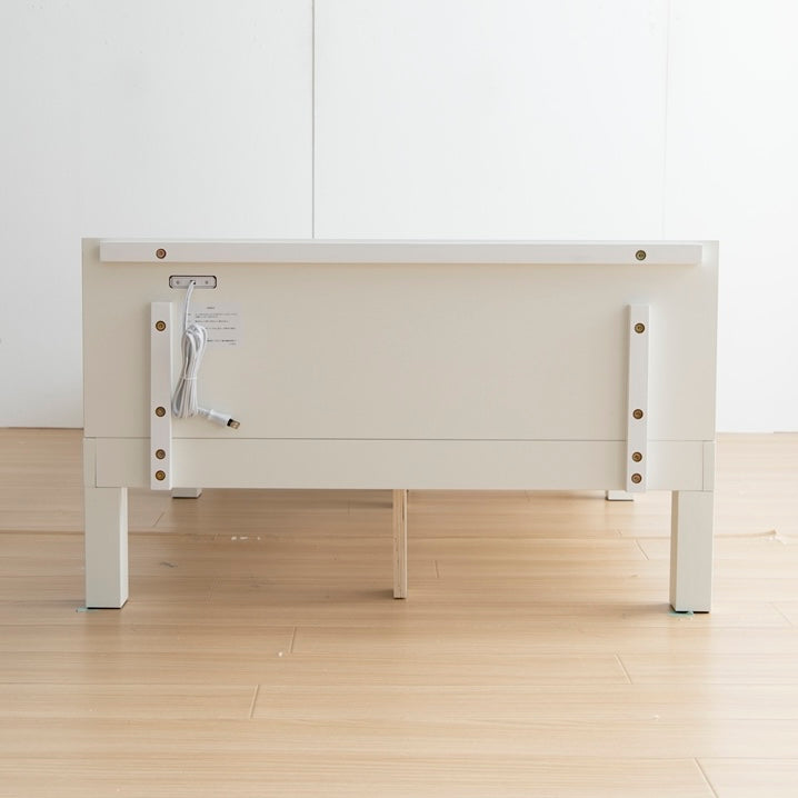 天然木製の白のヘッドボードに2口コンセントが付いたシンプルなベッドフレームのヘッドボードを裏側から見た写真