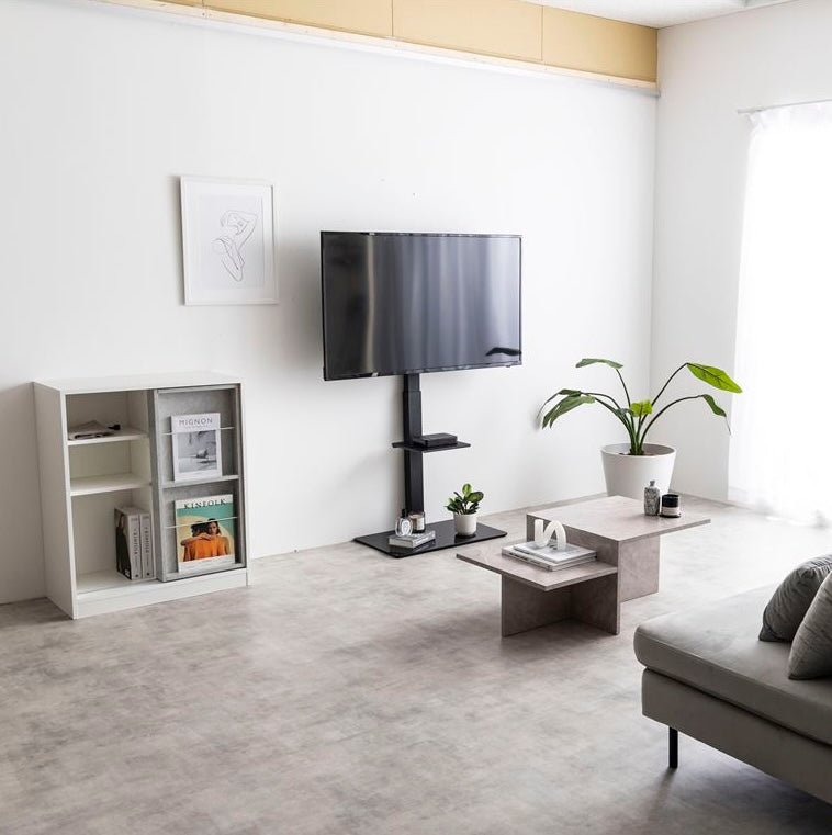 ラック付きのブラックのテレビスタンドが壁に寄せられている様子