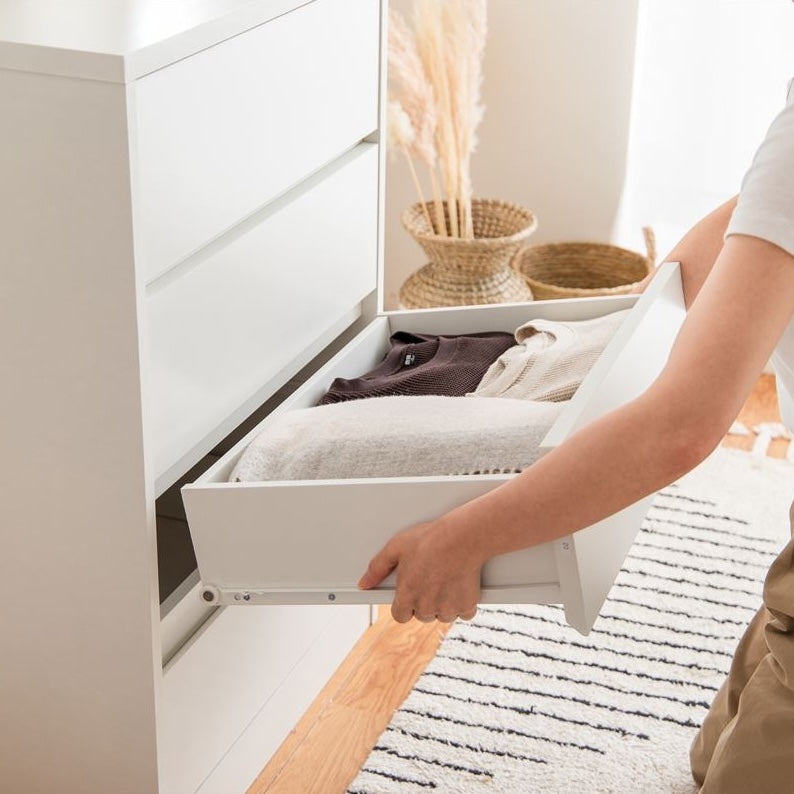 白の引き出しが4段のチェストの引き出しを1段引き抜いている様子