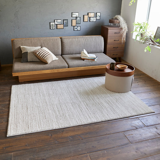アイボリーのナチュラルラグをソファ前に敷いている様子