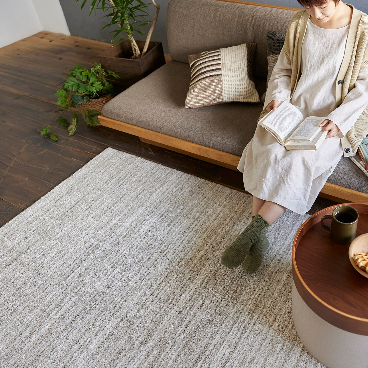 アイボリーのナチュラルラグをソファ前に敷いている様子