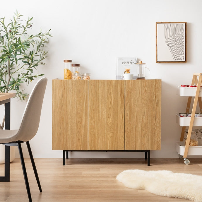 木目柄のバイカラーキャビネットがリビングに置かれている