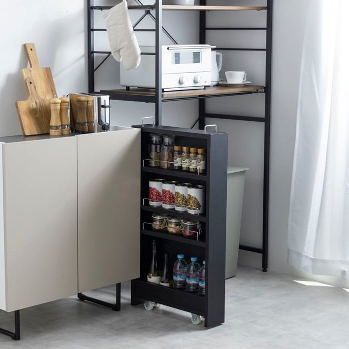 隙間に収まる黒の収納ワゴンをキッチンで使い、食品や水のストックを保管している