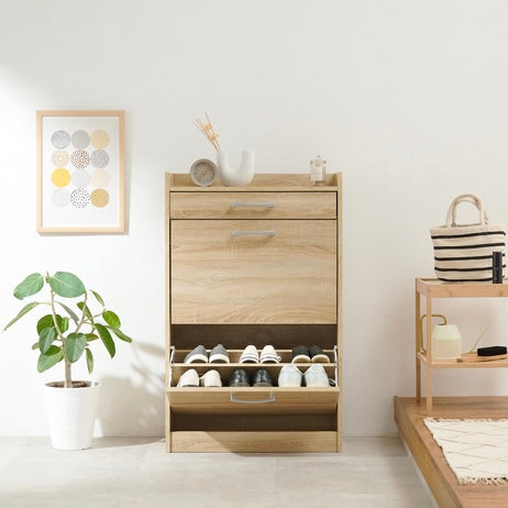 ナチュラルのフラップ扉式シューズケースに靴を収納している様子