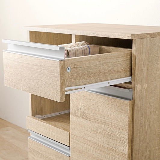 ナチュラルのキッチンボードのスライド引き出しに小物を収納している様子