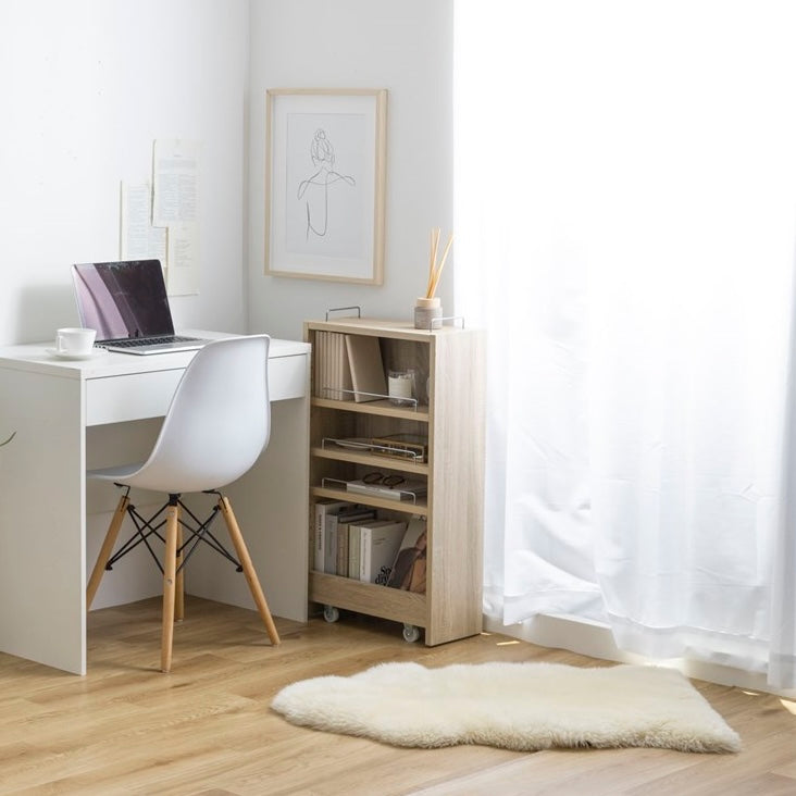 隙間に収まるナチュラルウッドカラーの収納ワゴンをデスク横で使い、本や文具、生活用品を収納している