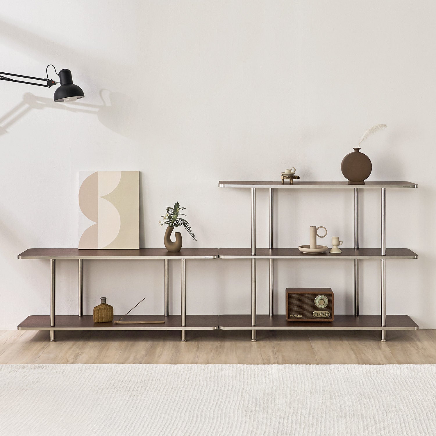 2段と3段のブラウンのオープンシェルフに花瓶やポスター、スピーカーなどが置かれてある様子