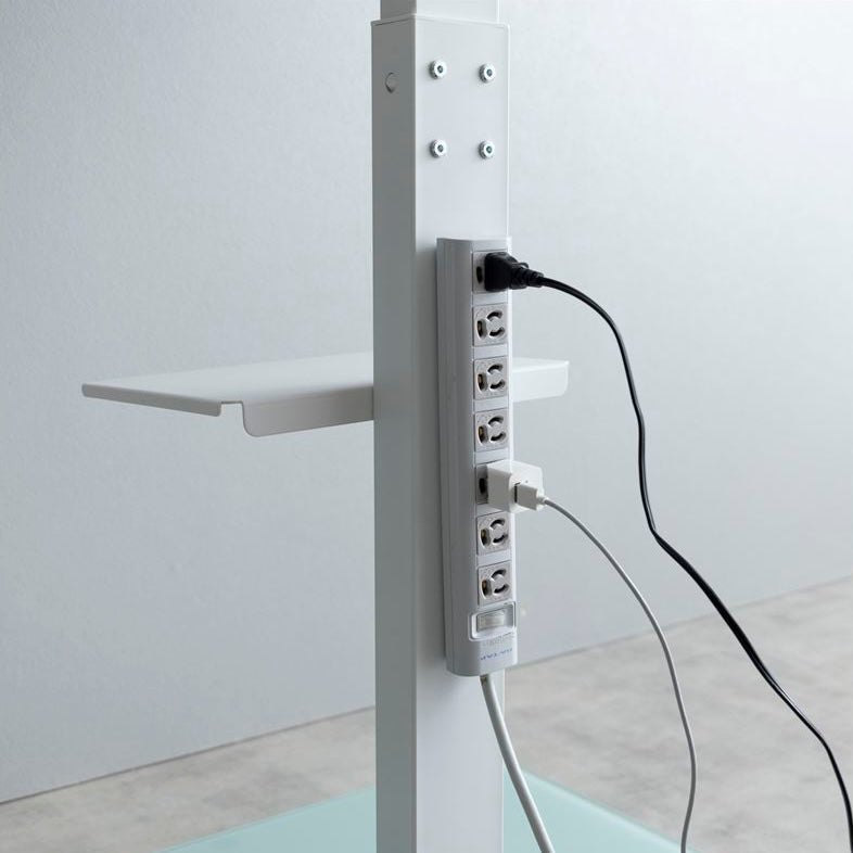 ラック付きのホワイトのテレビスタンドに磁石でタコ足配線をつけている様子