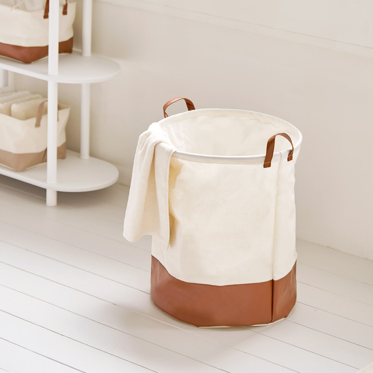 シェルフ横に置いてある巾着ラウンドバスケットブラウンの中にタオル等小物が入っている様子