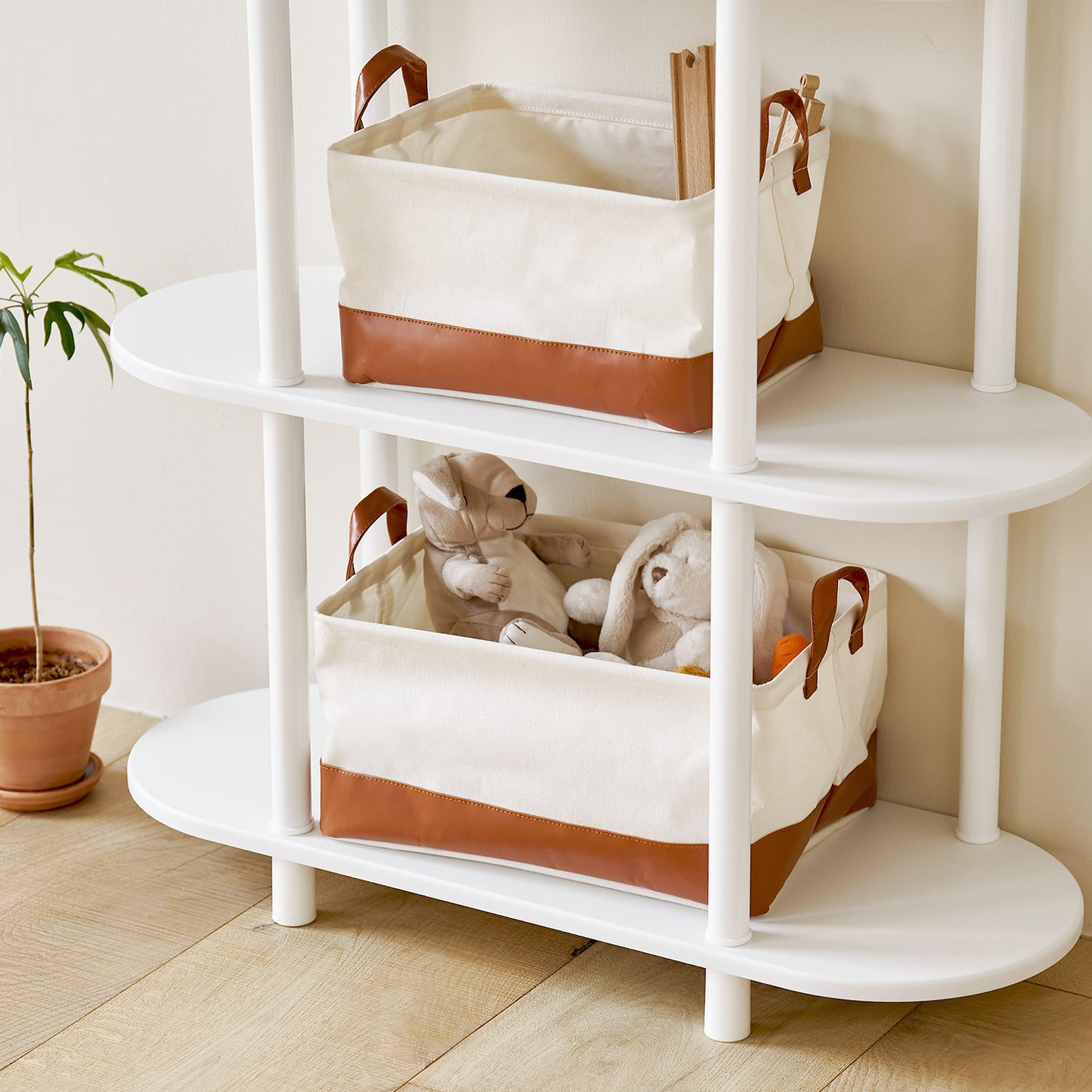 ブラウンのレザーと白地の巾着バスケットにぬいぐるみなどが入っている様子