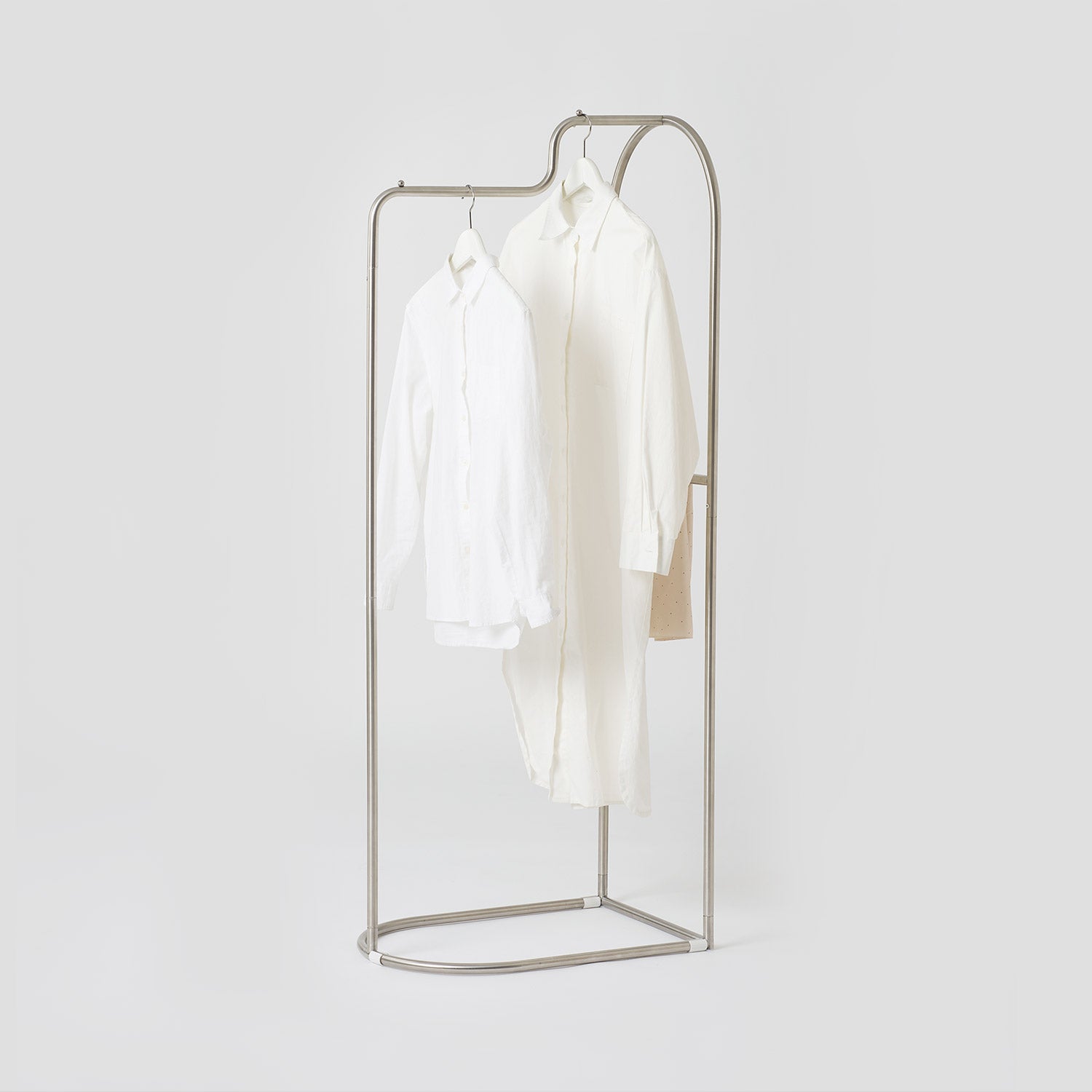Minimalistなシルバーの金属製アーチカーブハンガーに白いシャツが2枚かかっています roomnhomeの製品です
