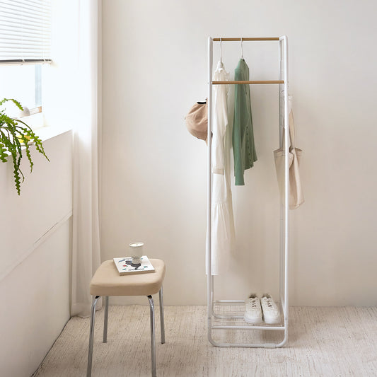 天然木とスチールを組み合わさったコンパクトな白のハンガーラックが部屋にある様子