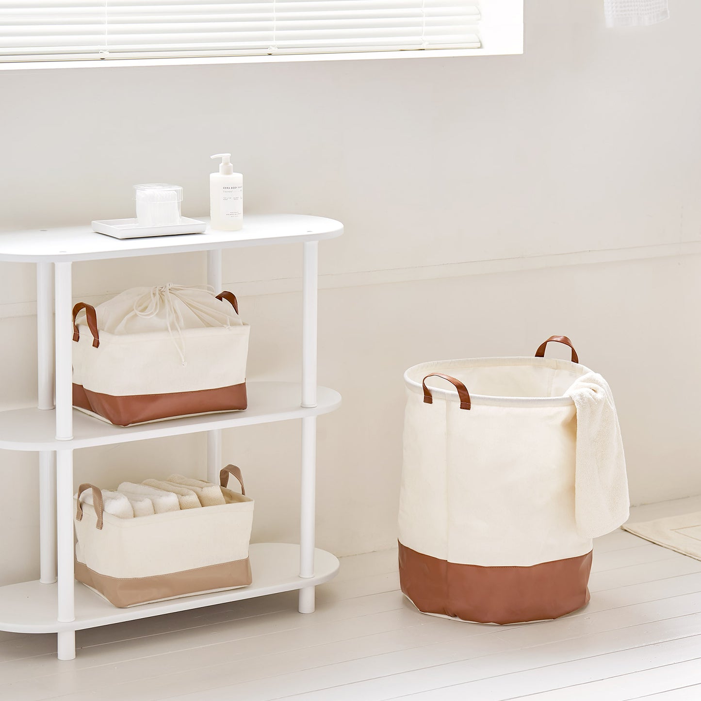 シェルフ横に置いてある巾着ラウンドバスケットブラウンの中にタオル等小物が入っている様子