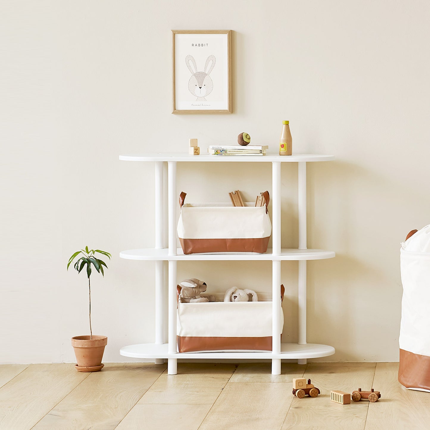 ブラウンのレザーと白地の巾着バスケットのサイズ違いを棚に置いている様子