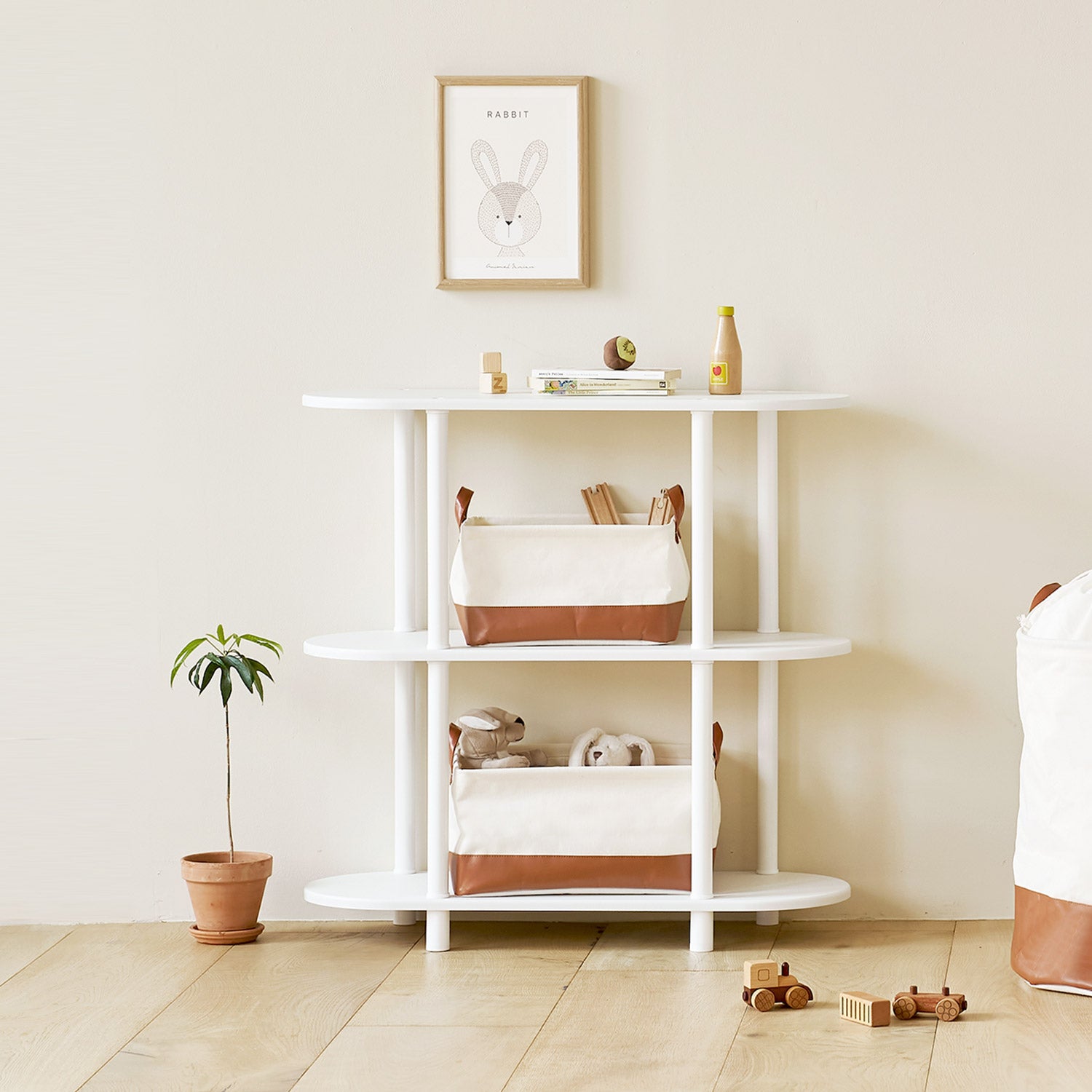 ブラウンのレザーと白地の巾着バスケットのサイズ違いを棚に置いている様子