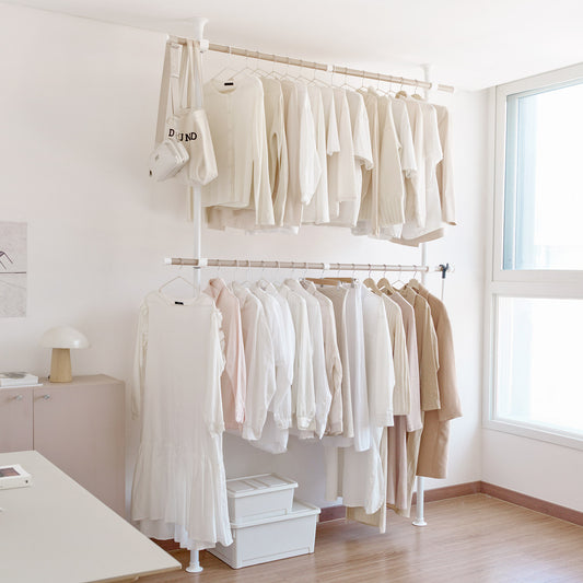 2列の突っ張りハンガーラックに服がかかっている様子