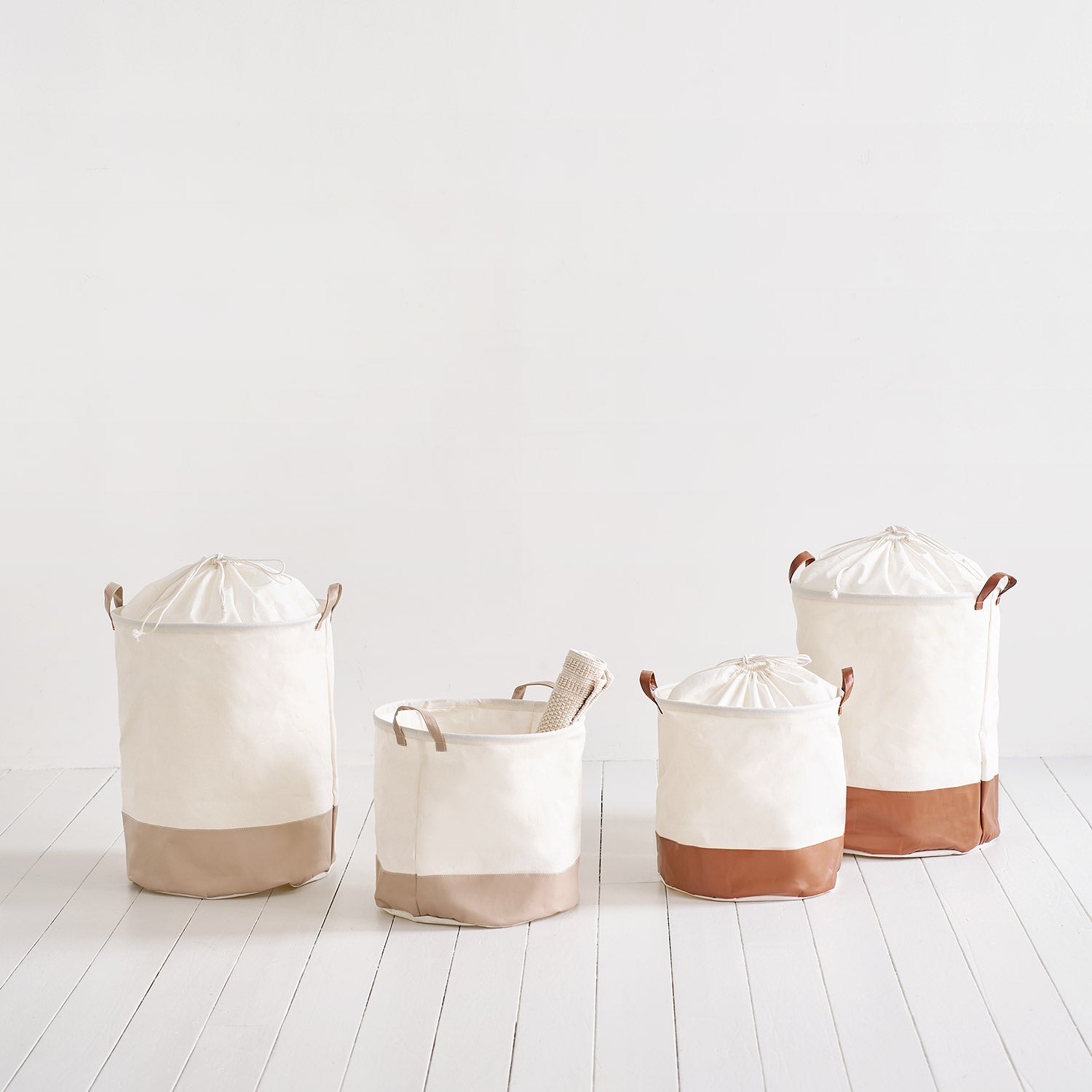 巾着ラウンドバスケットベージュとブラウンのそれぞれM・Lサイズが並んで置いてある様子