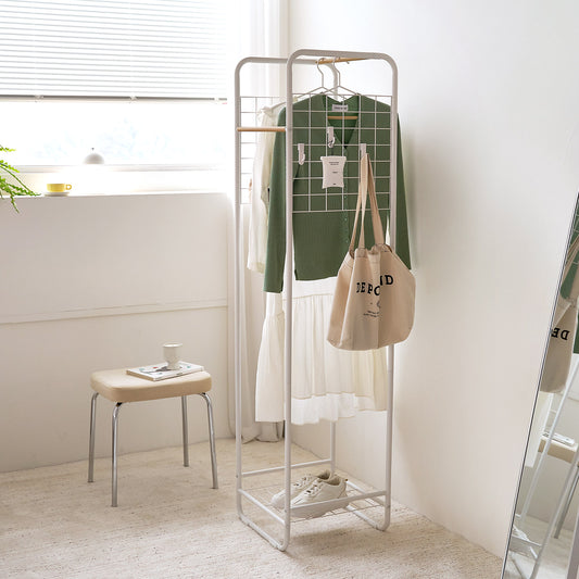 天然木とスチールを組み合わさったコンパクトな白のハンガーラックが部屋にある様子