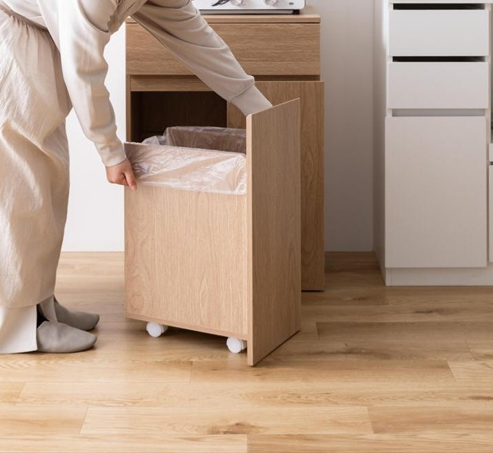 ゴミ箱とキッチンボードが一体となった収納家具のゴミ箱部分にゴミ袋をかけている写真