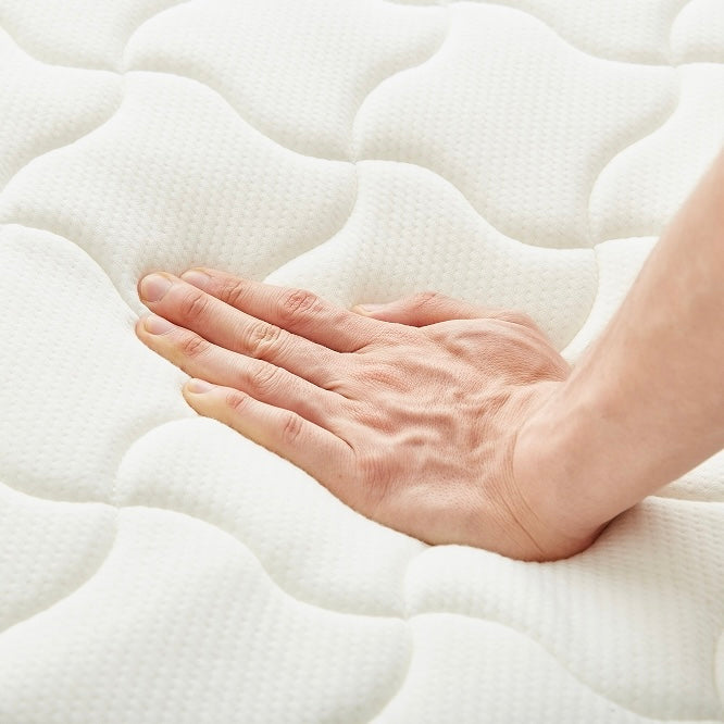 ホワイトのポケットコイルマットレスに手を置いている様子