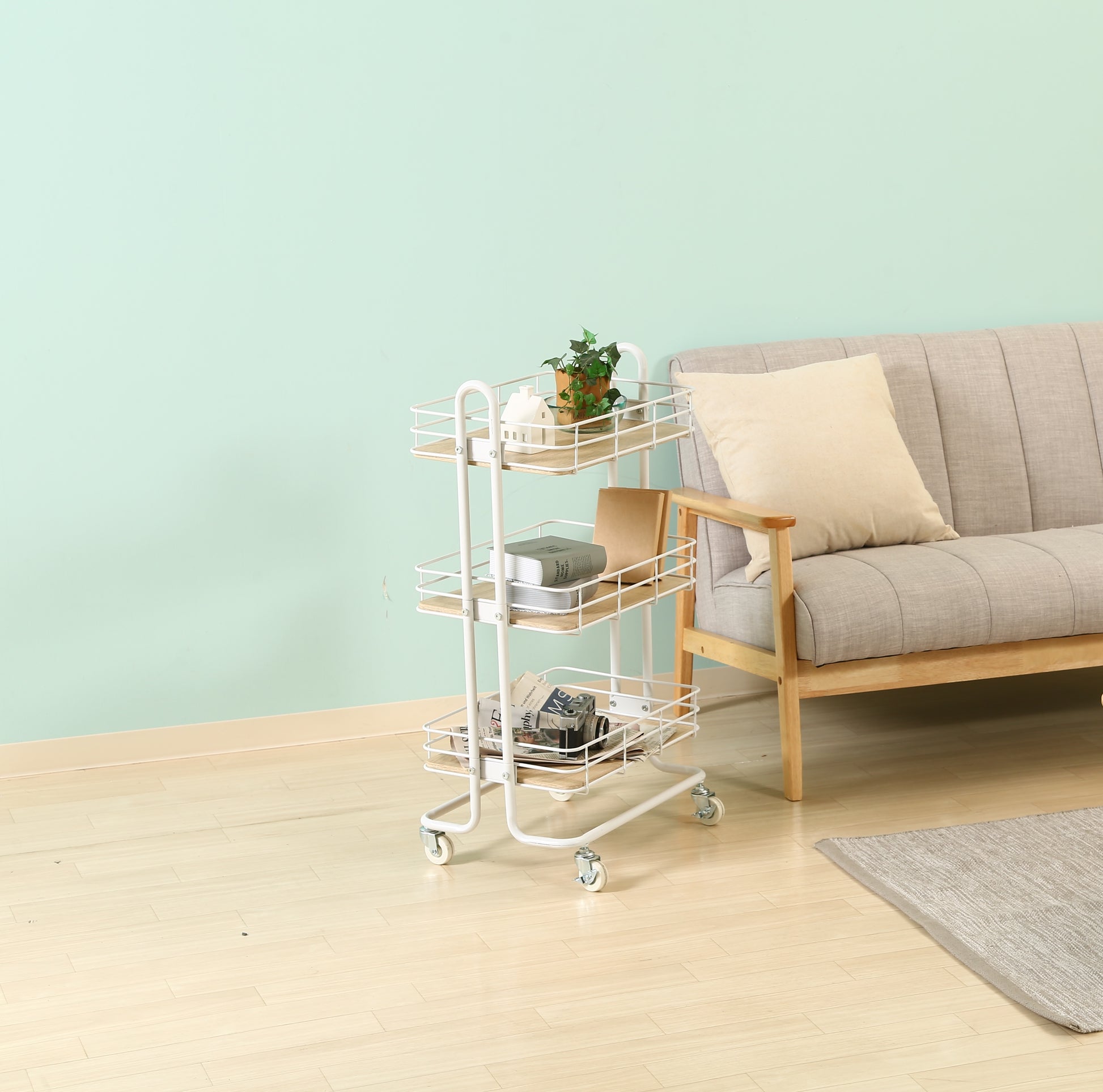 ウッド天板でホワイトフレームのワゴンをソファ横に置いている様子