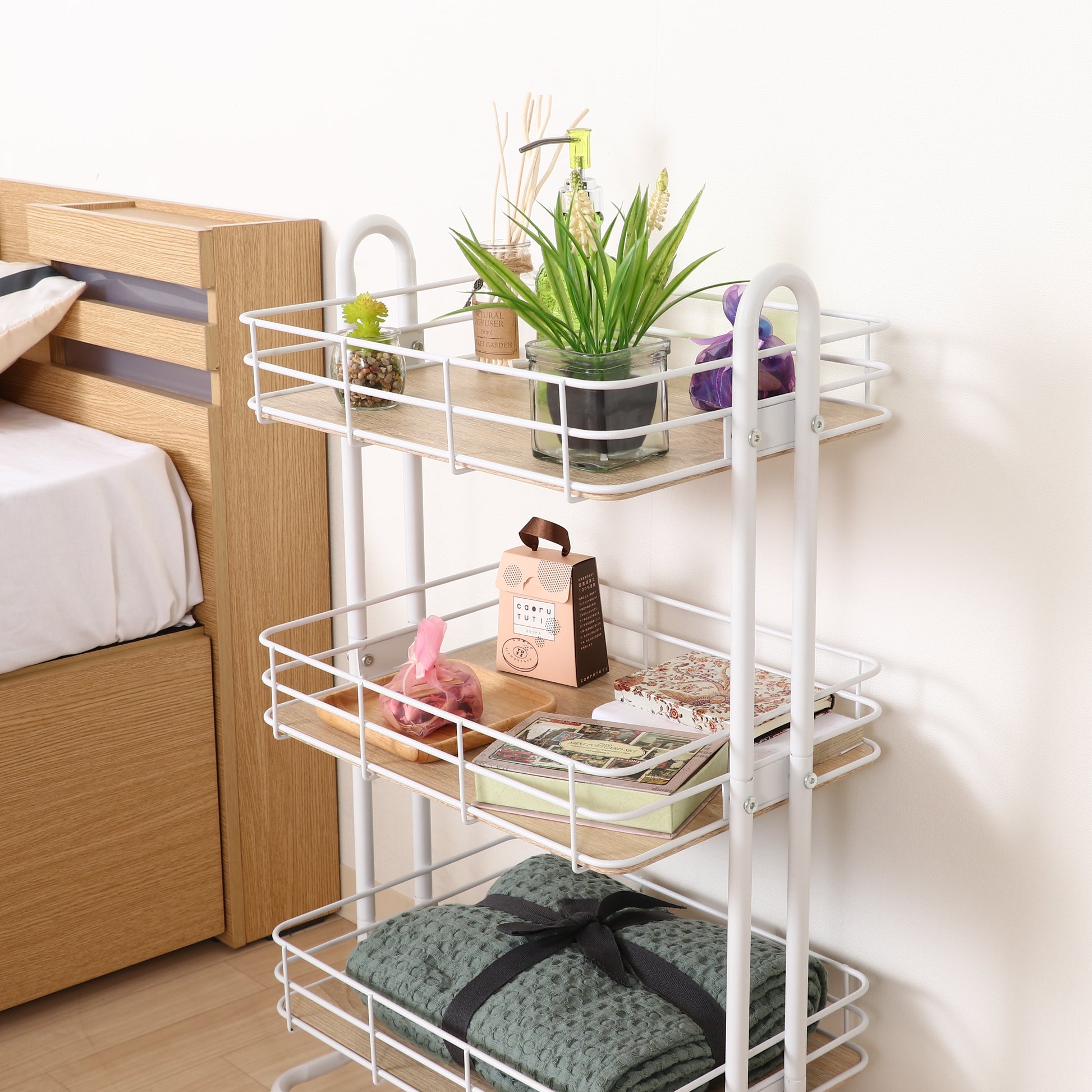 ウッド天板でホワイトフレームのワゴンに植物や小物などが置かれてある様子