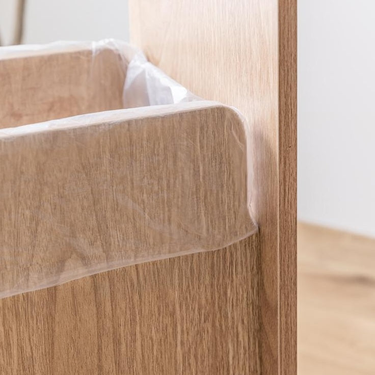 ゴミ箱とキッチンボードが一体となった収納家具のゴミ箱部分に袋を引っ掛けるスリットがついている様子