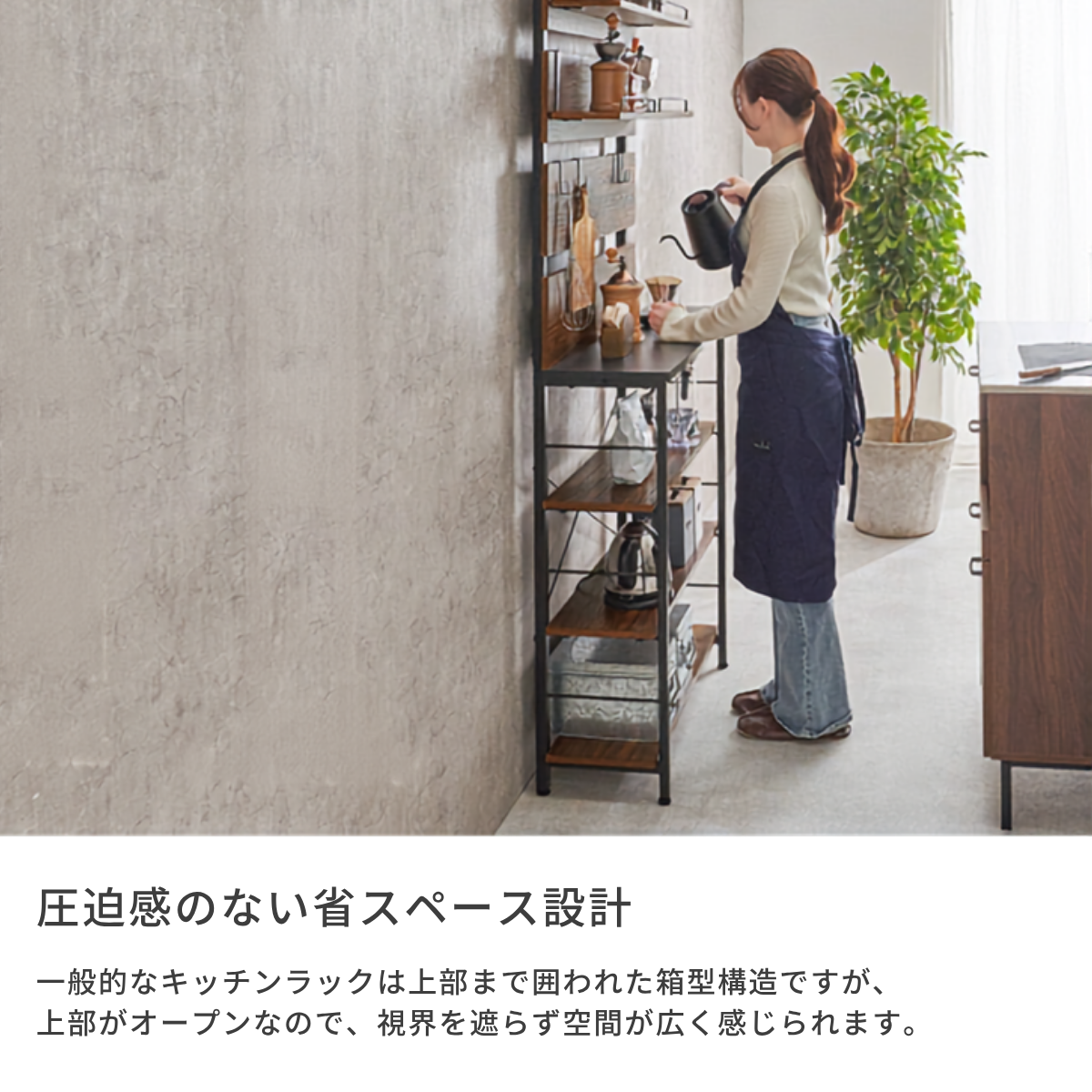 暗い青色のシンプルでストレートカットデザインのエプロンを着た女性と突っ張りキッチンラック