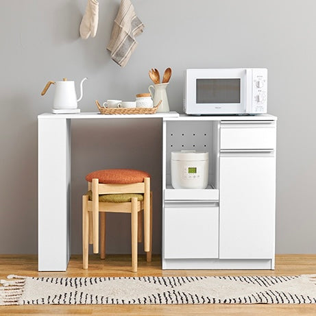 ホワイトのキッチンボードに調理器具やストック品が収納されている様子