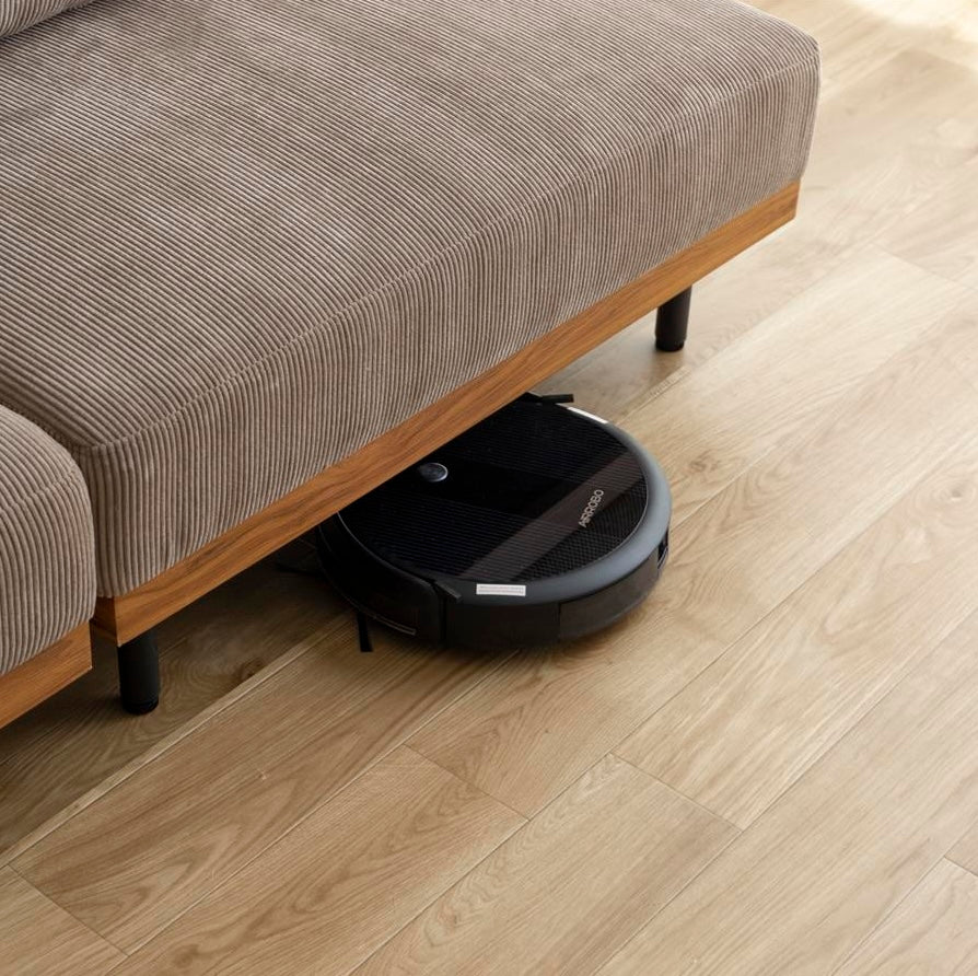 ブラックの円形ロボット掃除機でマット仕上げと控えめなロゴが特徴の製品です