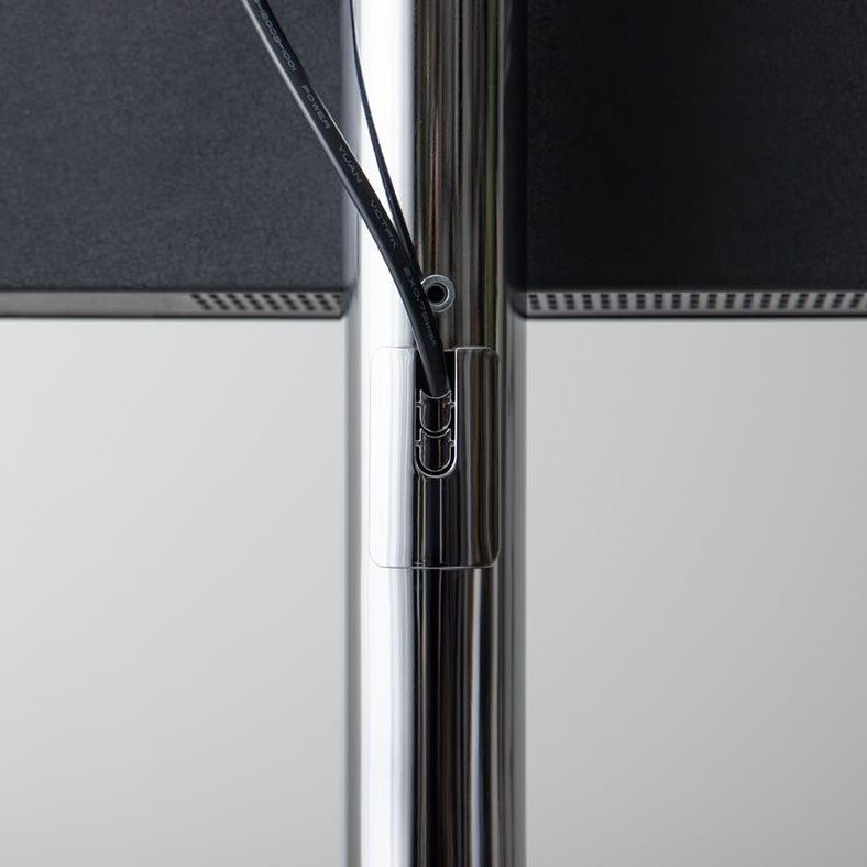 シルバーポールのテレビスタンドのポールからテレビのコードが出ている様子