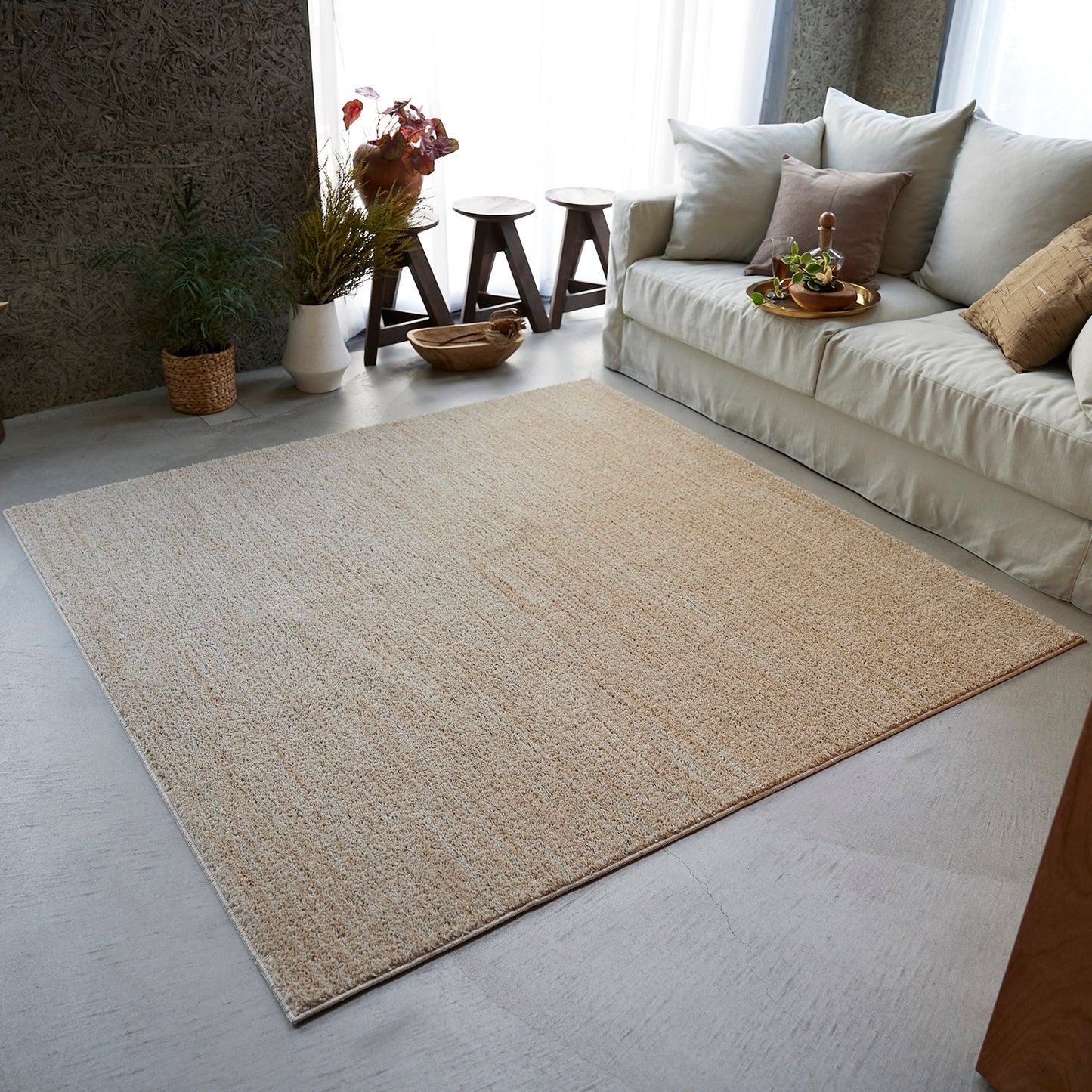 ベージュのナチュラルラグを部屋に敷いている様子