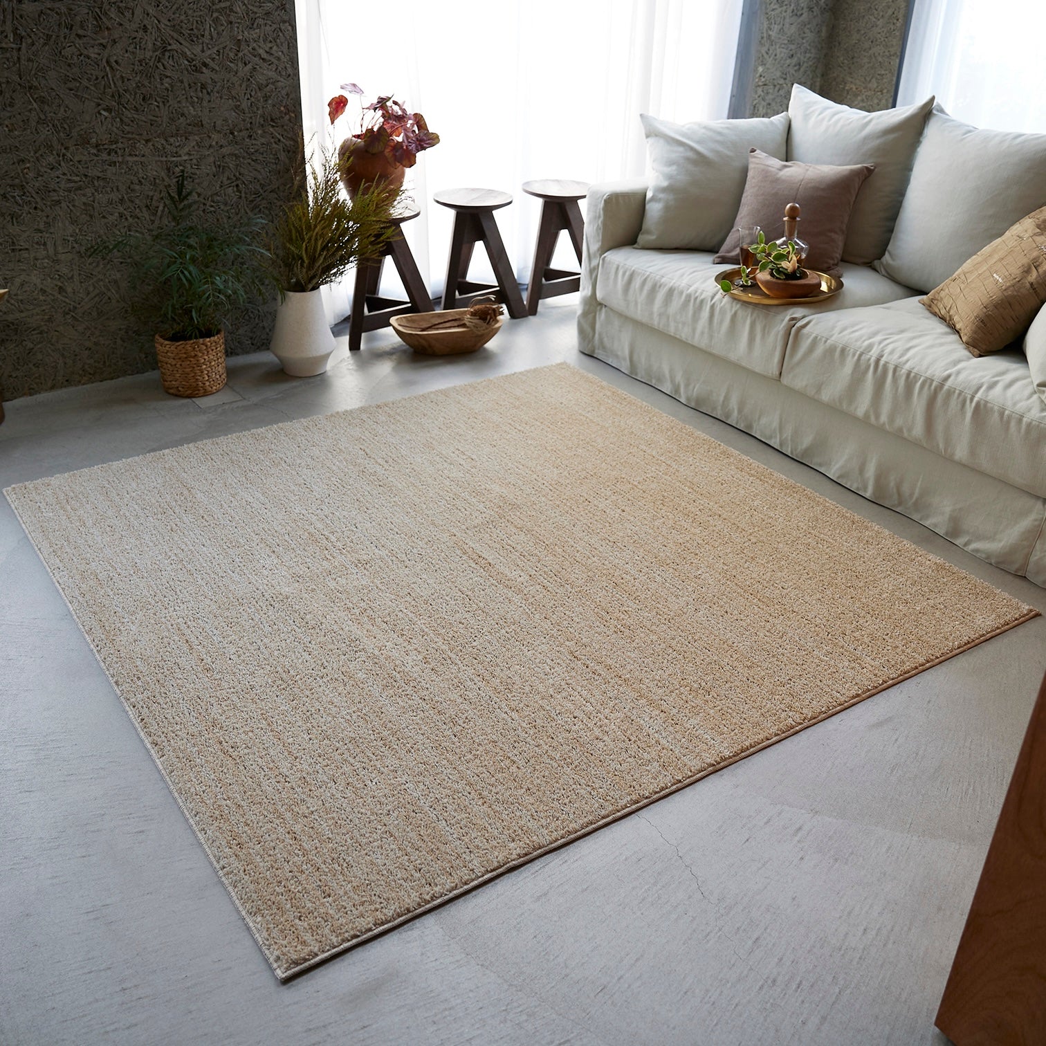 ベージュのナチュラルラグを部屋に敷いている様子