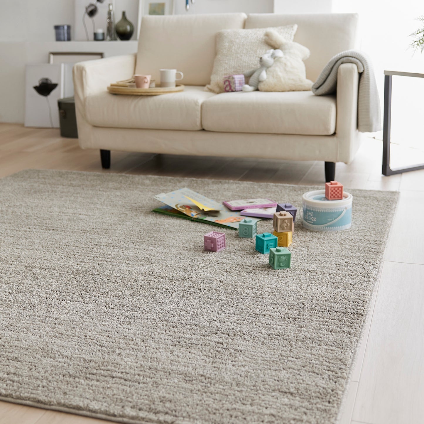 グレージュのナチュラルラグの上にブロックのおもちゃが置いてある様子